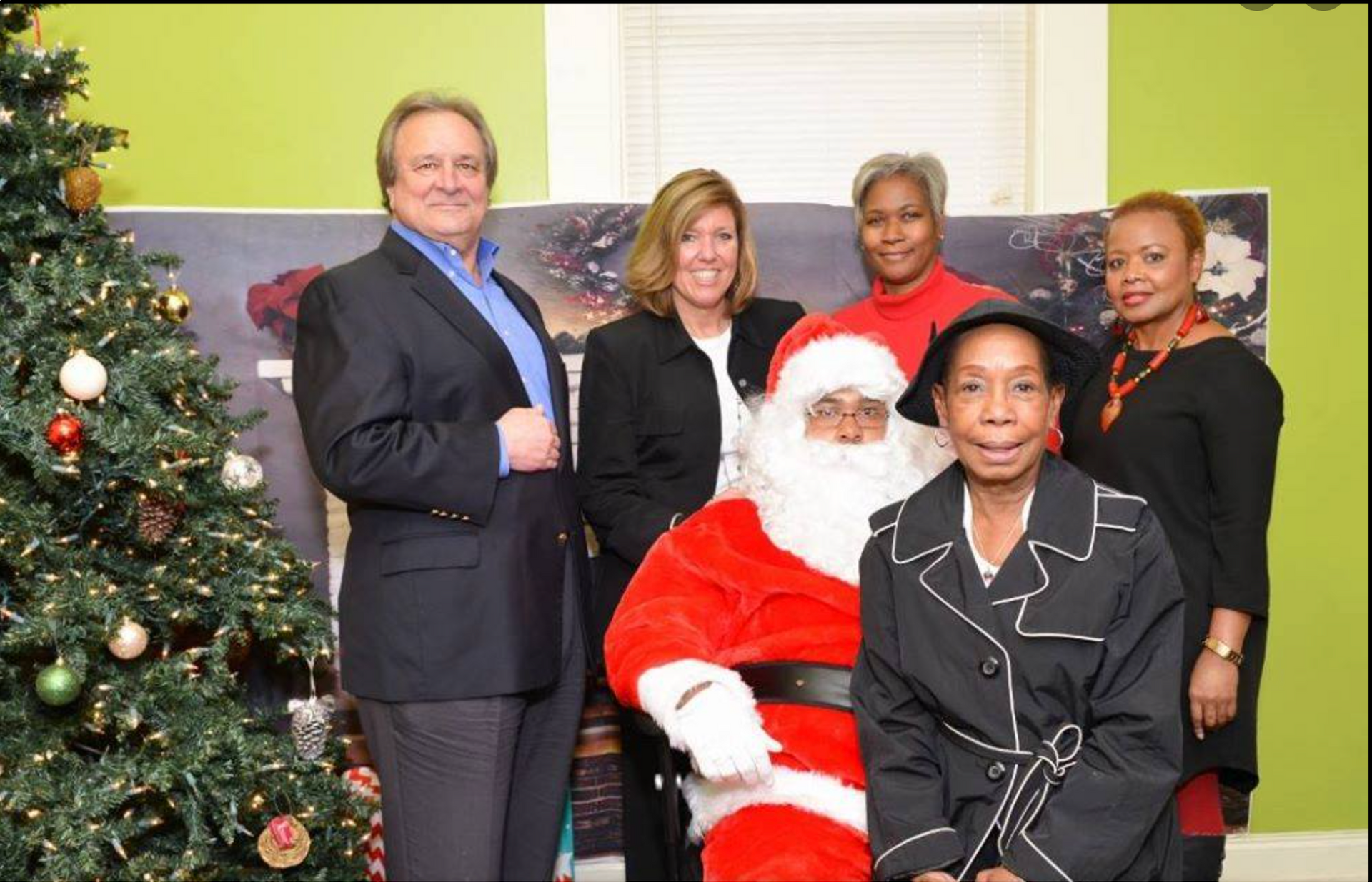 A group of people posing for a picture with santa claus