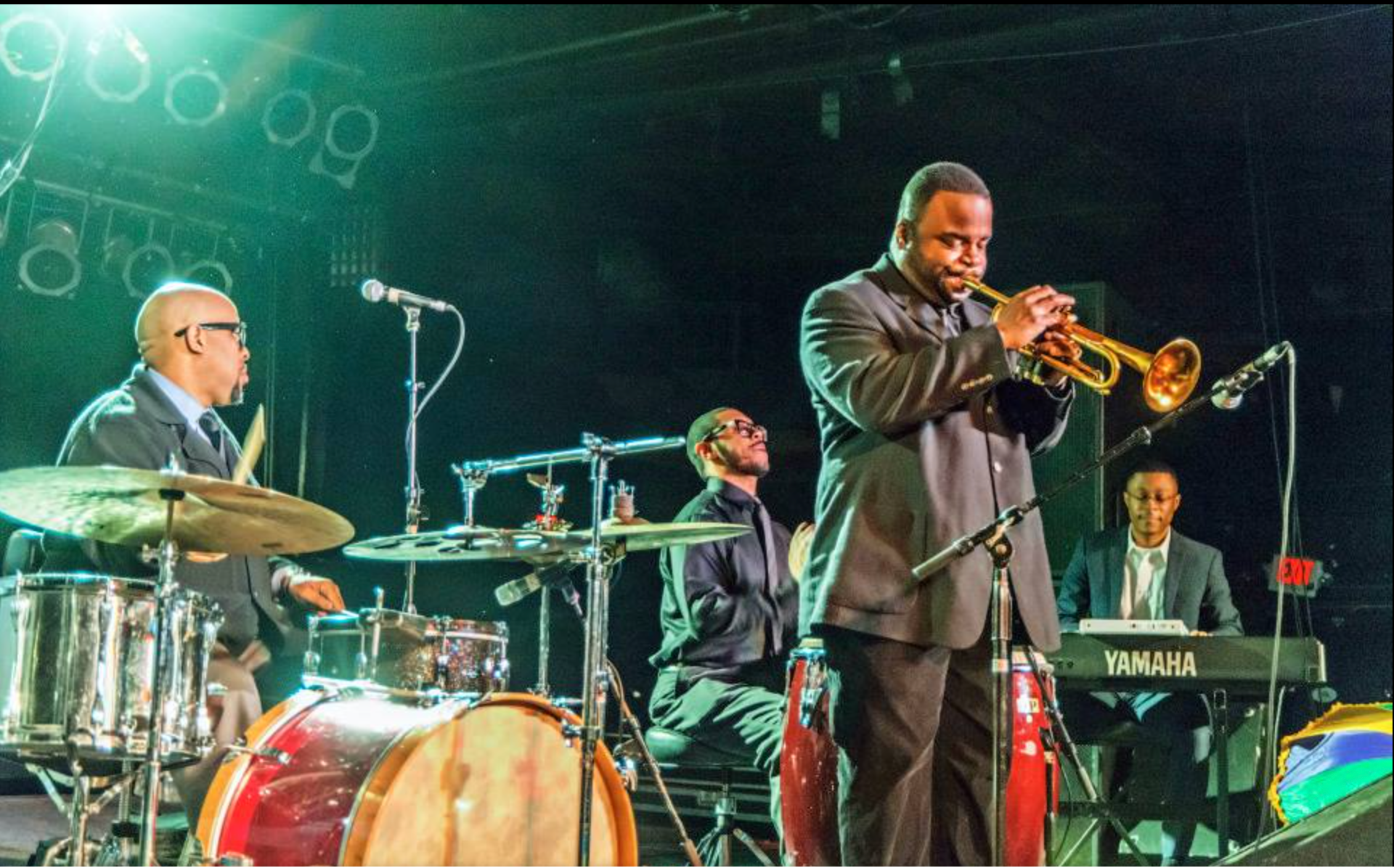 A man playing a trumpet in front of a yamaha keyboard