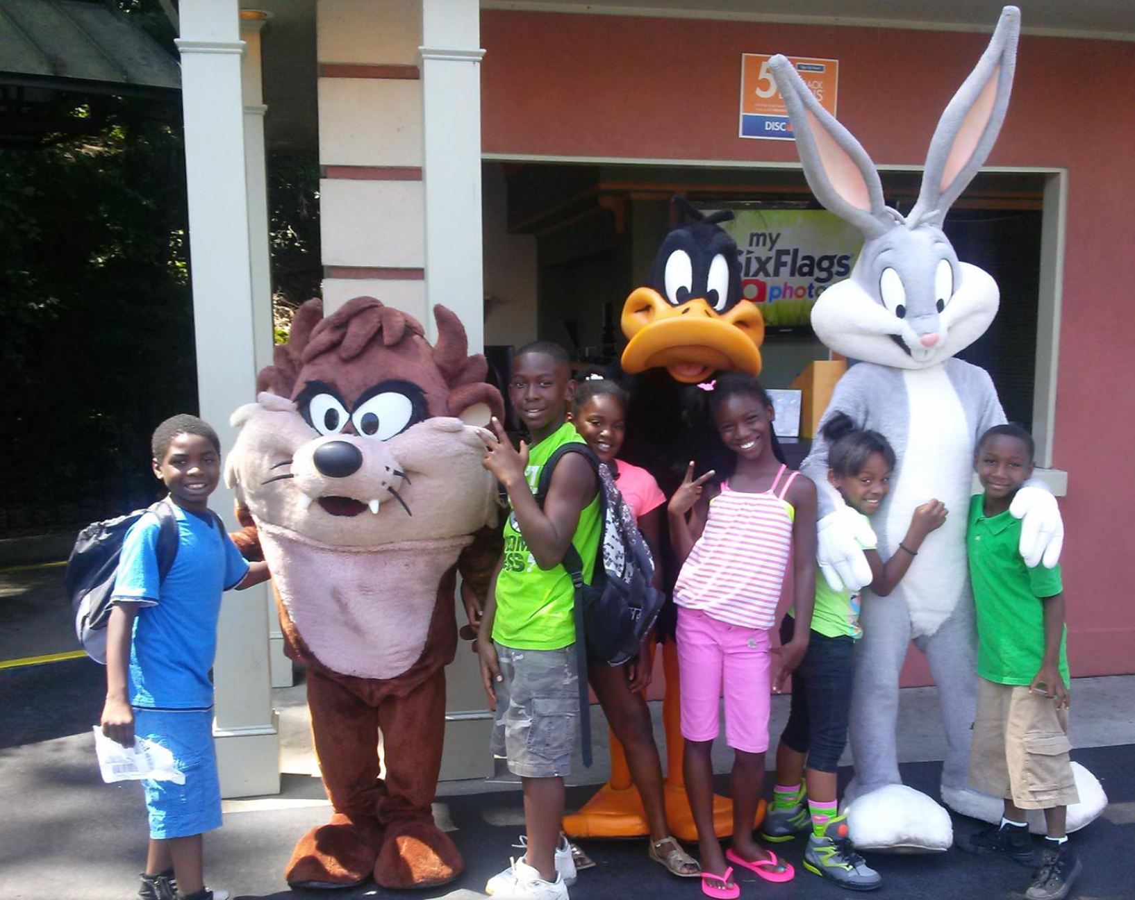 A group of children pose with bugs bunny and taz