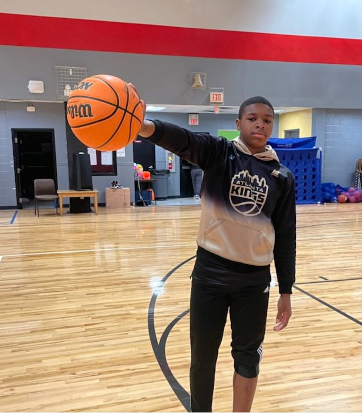 A young boy is holding a basketball with the word kings on it