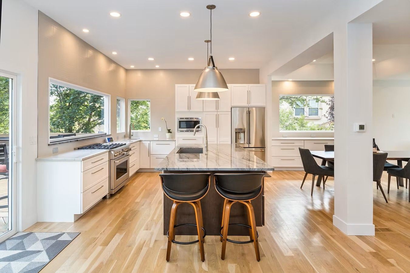 Modern kitchen with island, stainless steel appliances, and wood flooring.
