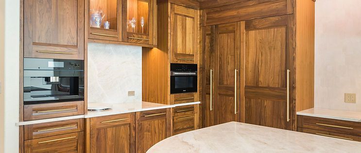 Wooden kitchen cabinets with built-in appliances and a white countertop.