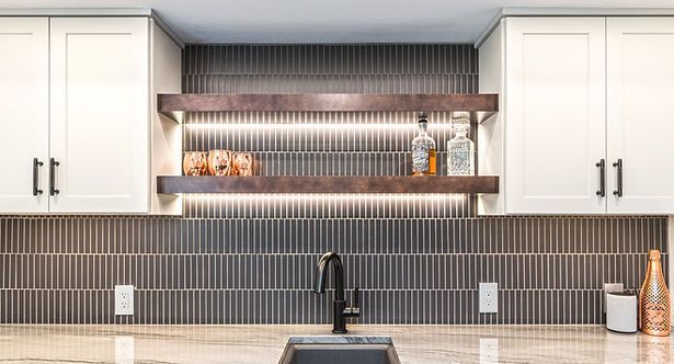 Kitchen backsplash with tile, shelves, cabinets, and sink.