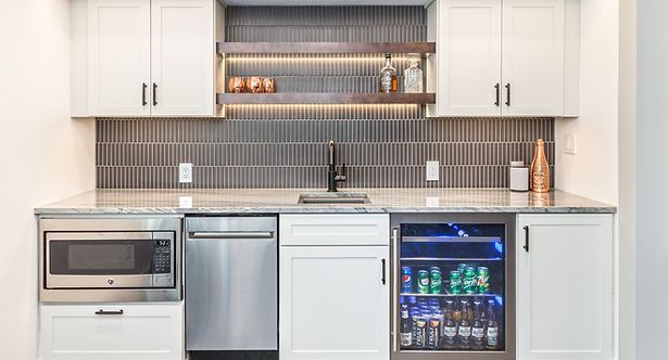 White cabinetry with a microwave, dishwasher, and beverage cooler in a home bar setting.