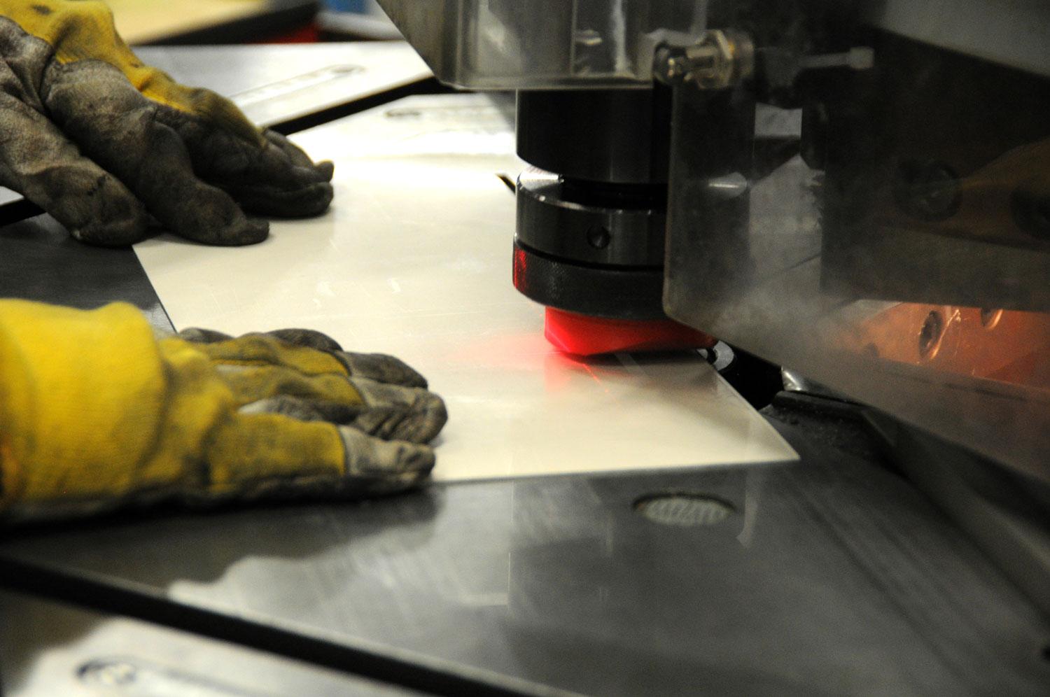 Degli uomini in una fabbrica al lavoro con delle lamiere