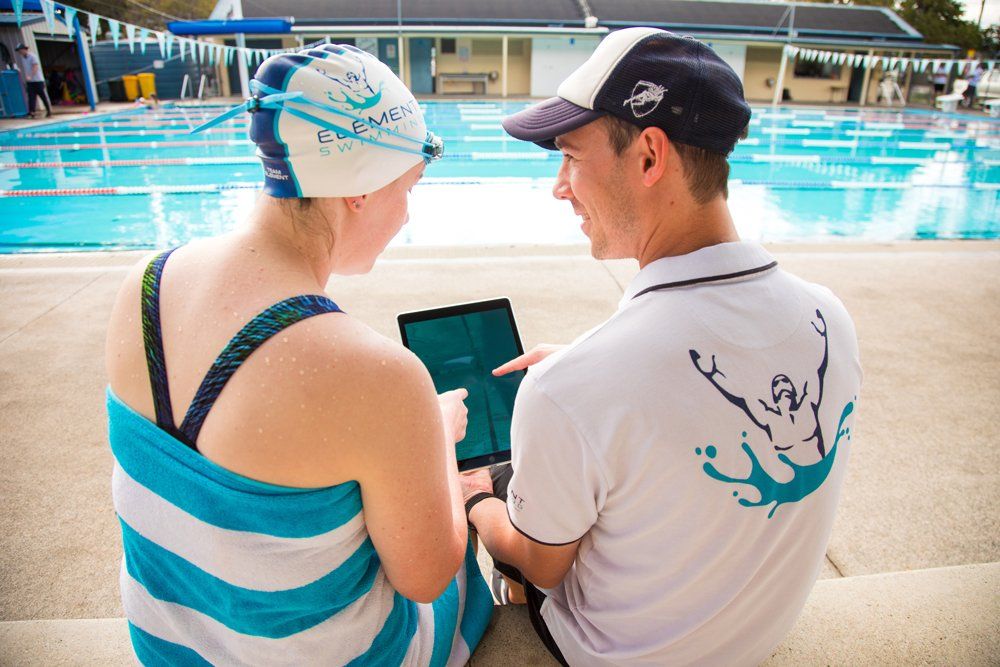 Coach and swimmer discussing with an ipad