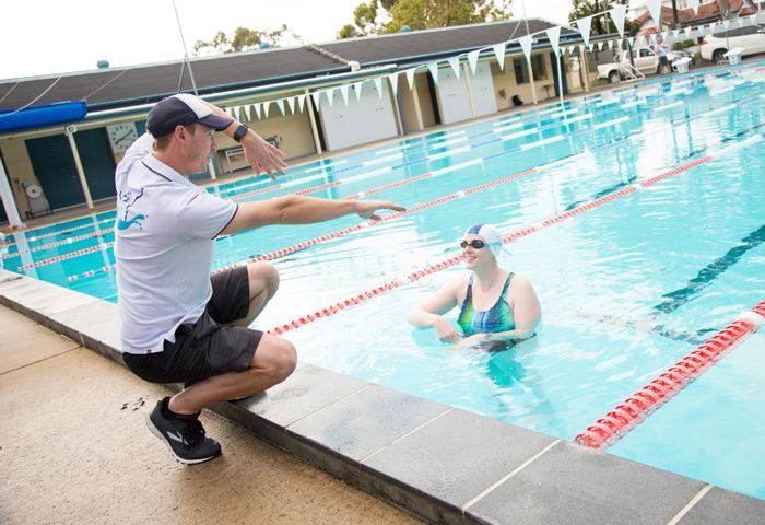 Coach showing swimmer freestyle arms