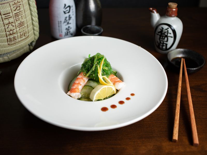A plate of food with chopsticks on a wooden table.