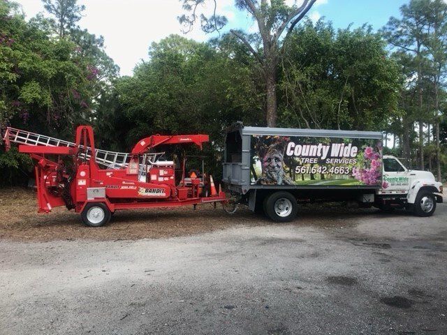 Red Truck And The Company Truck — Lantana, FL — Countywide Tree Service
