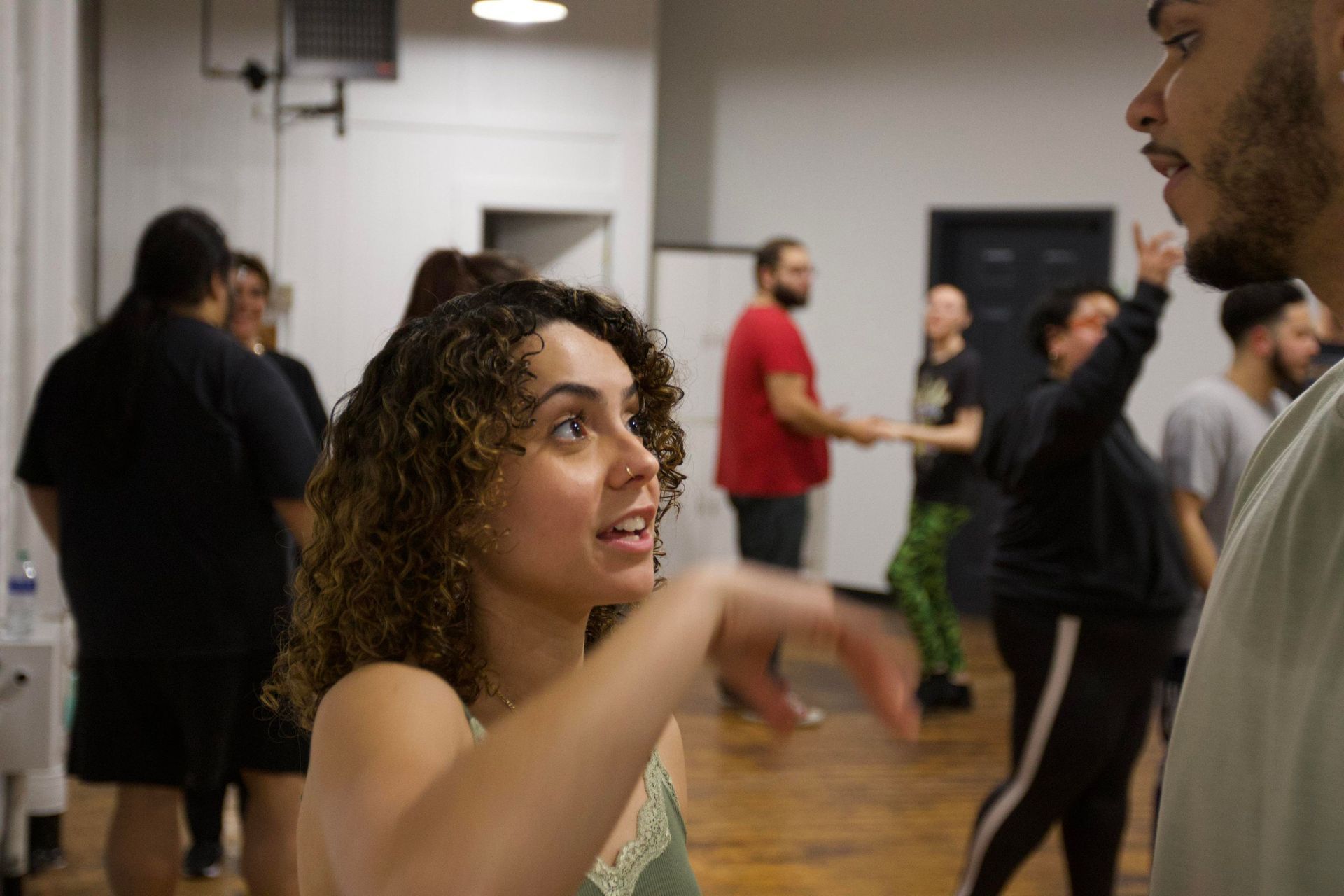 A young female student talks to her male partner during a Bachata class.