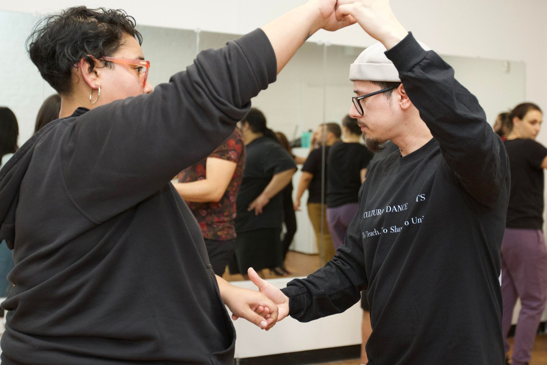 Instructors Brandon and Kristy teach partnerwork choreography in front of students in a Bachata class.