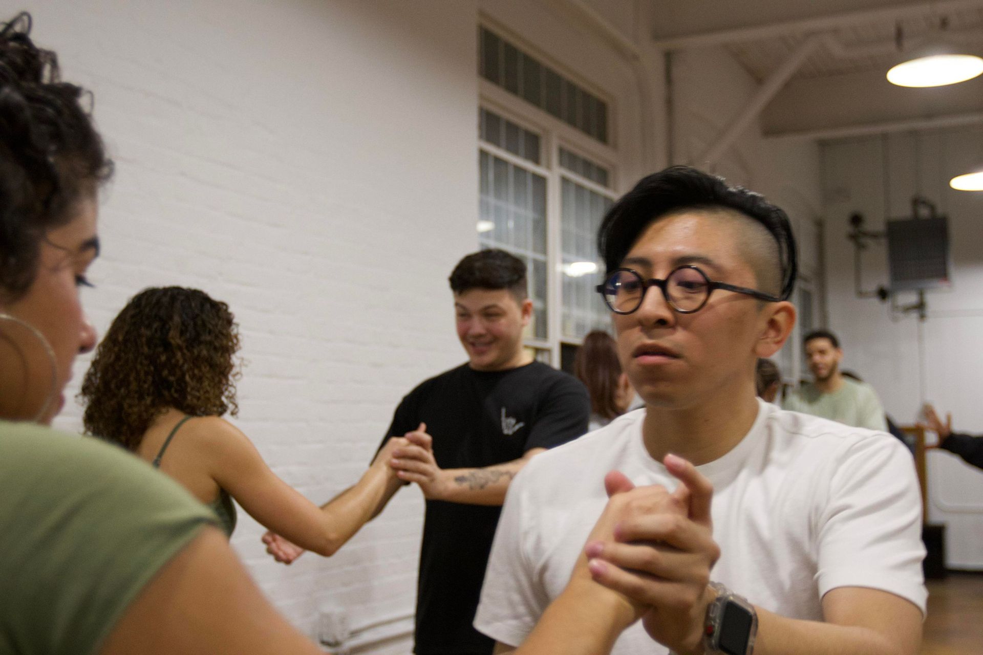 A male student concentrates on Bachata partner work choreography with his female dance partner.