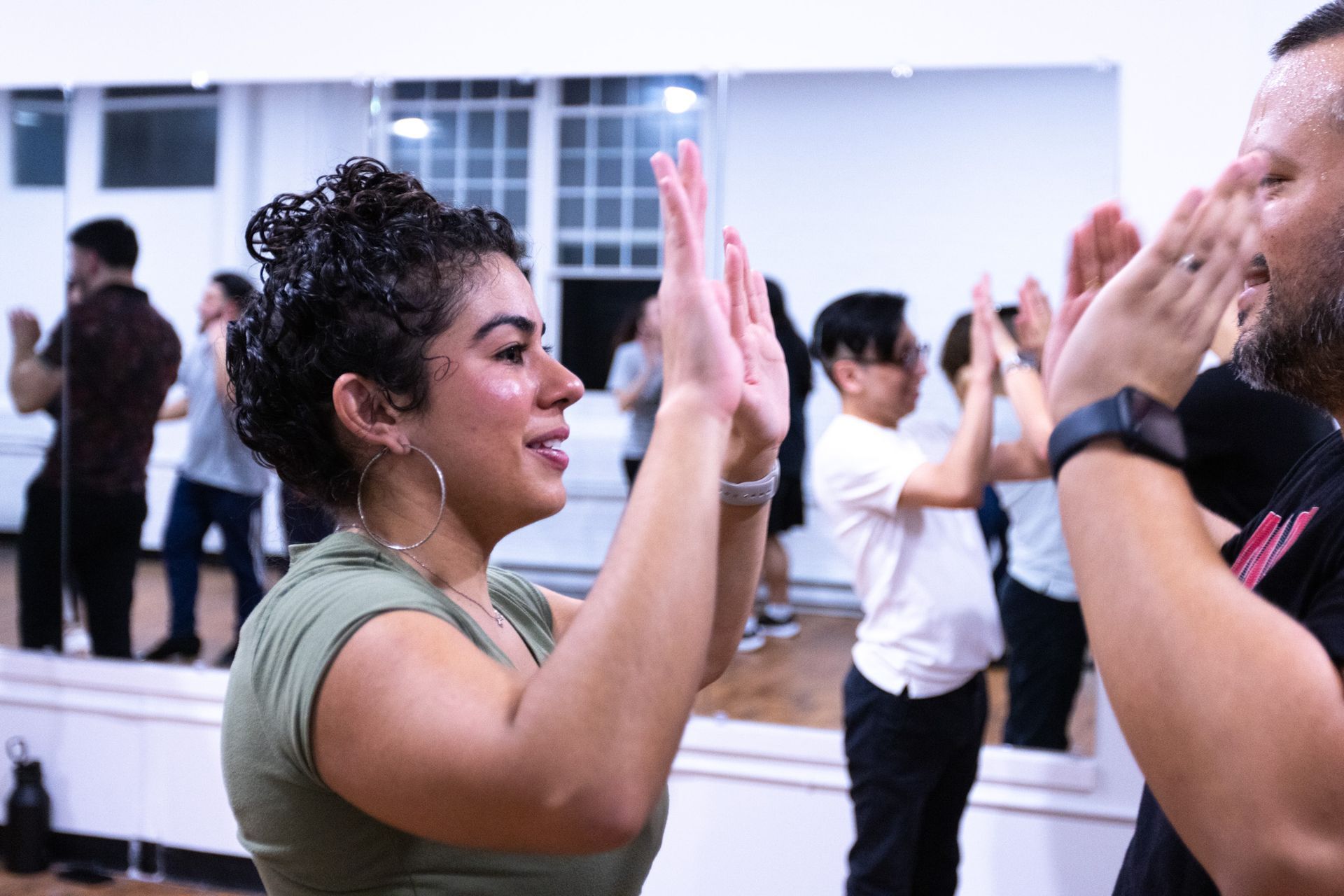 A female and male student high five during a Bachata class.