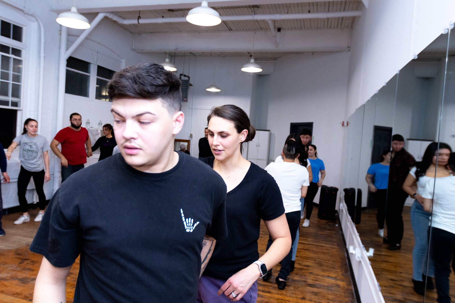 A male student spins while leading his female dance dance partner during a Bachata class.