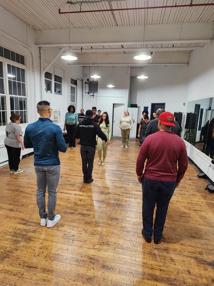 Instructor Brandon explains a dance move to his students during a Kizomba class.