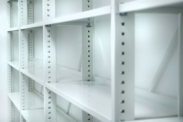 To barn i en skolegang med skap. Ett barn henger opp ting, det andre ser på.