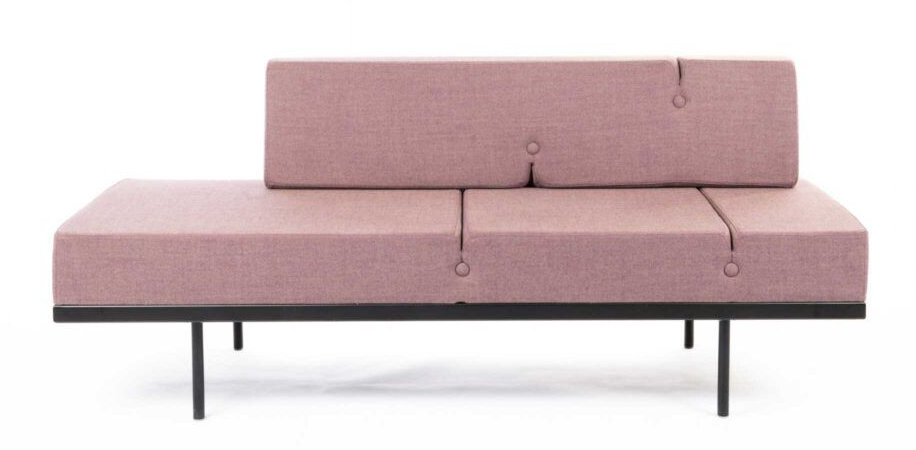 Rosa modulsofa i stoff med svarte metallben.