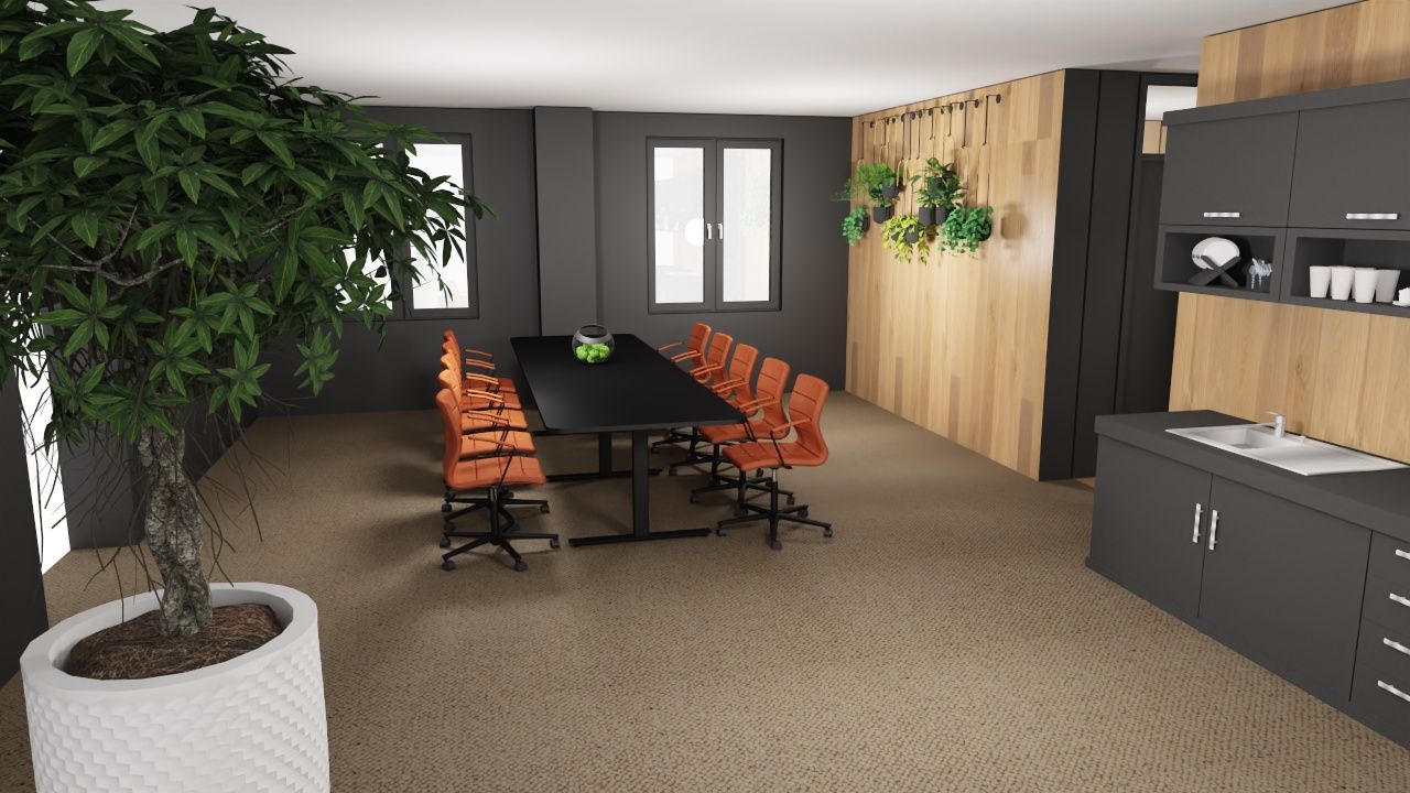 Konferanserom med svart bord, oransje stoler og et kjøkkenområde med grå skap og en stor potteplante.