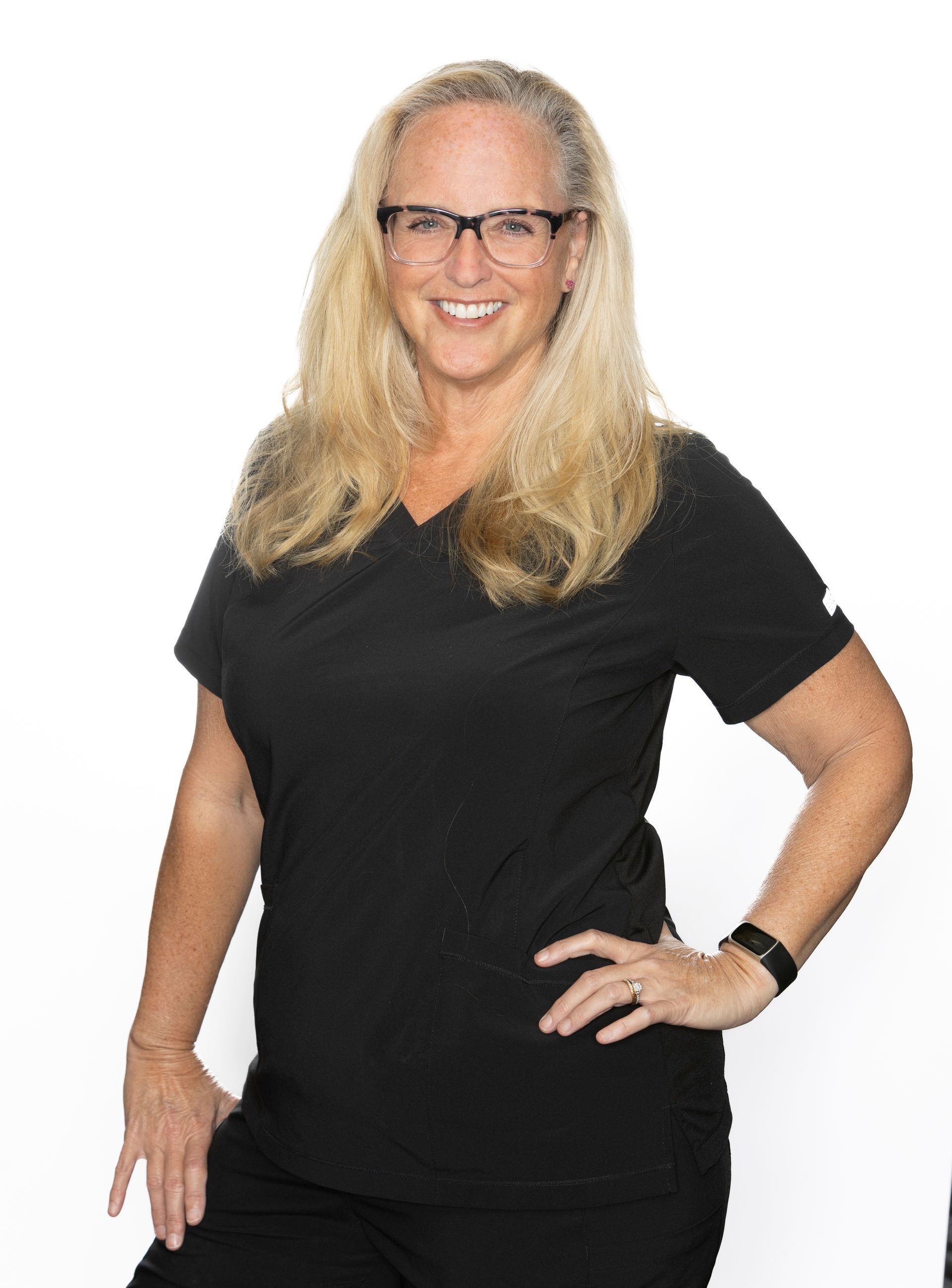 A woman wearing glasses and a headband is smiling for the camera.