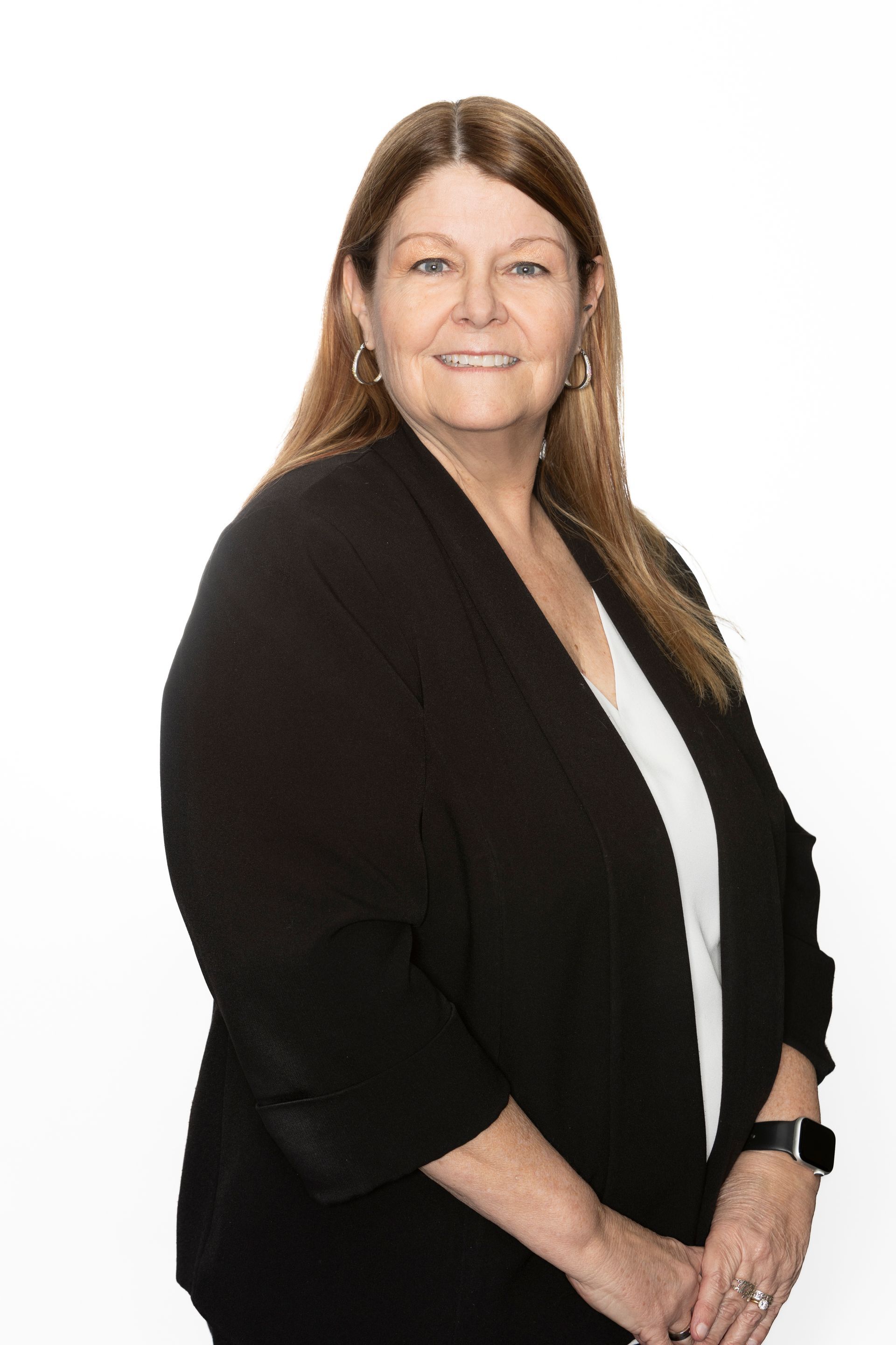 A woman wearing a black jacket and a purple shirt is smiling for the camera.