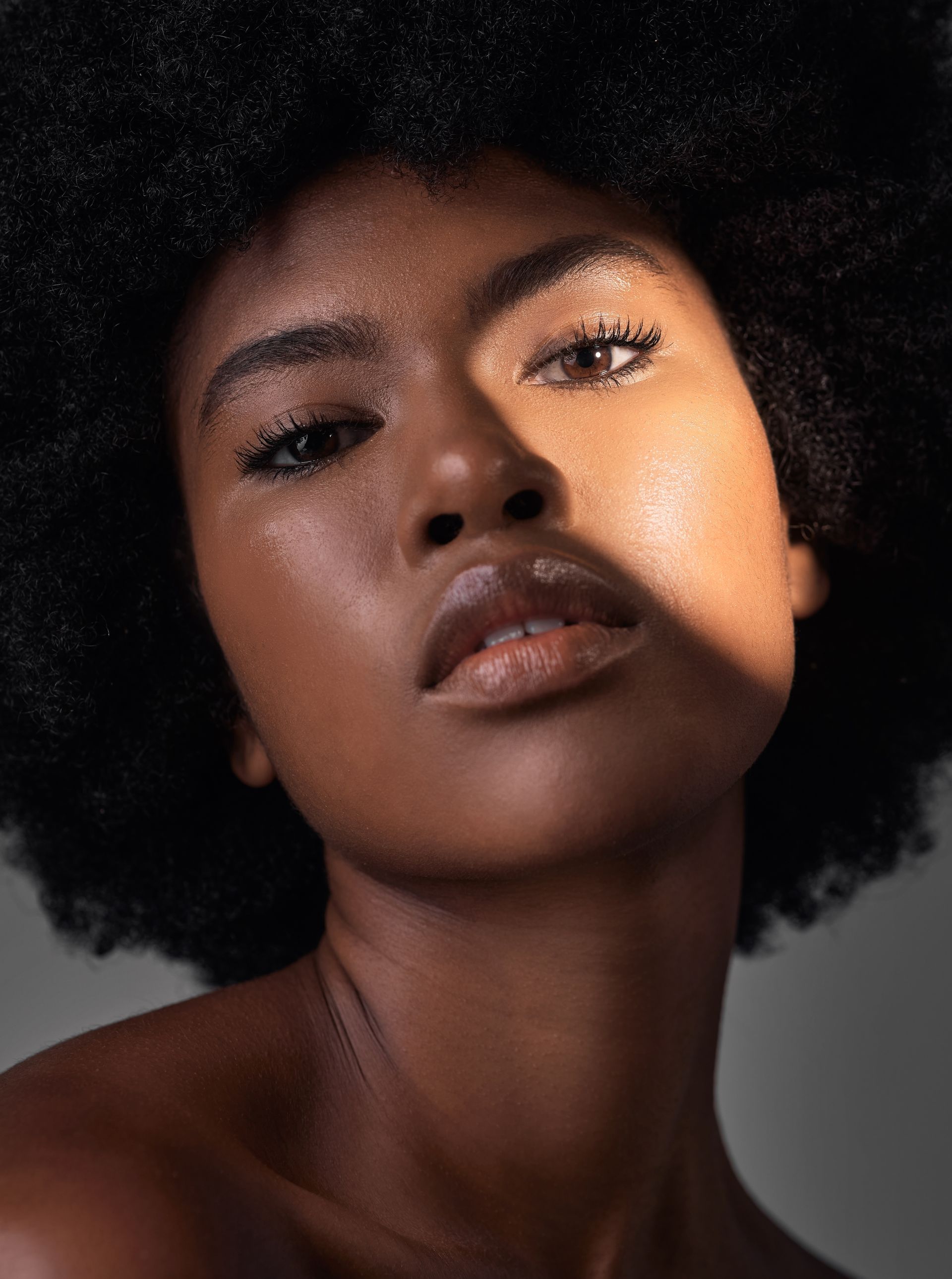A close up of a woman 's face with an afro.