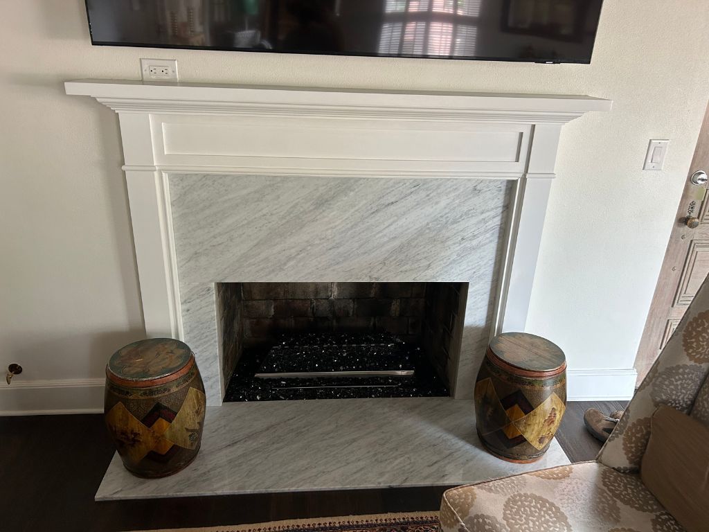 A living room with a fireplace and a flat screen tv.