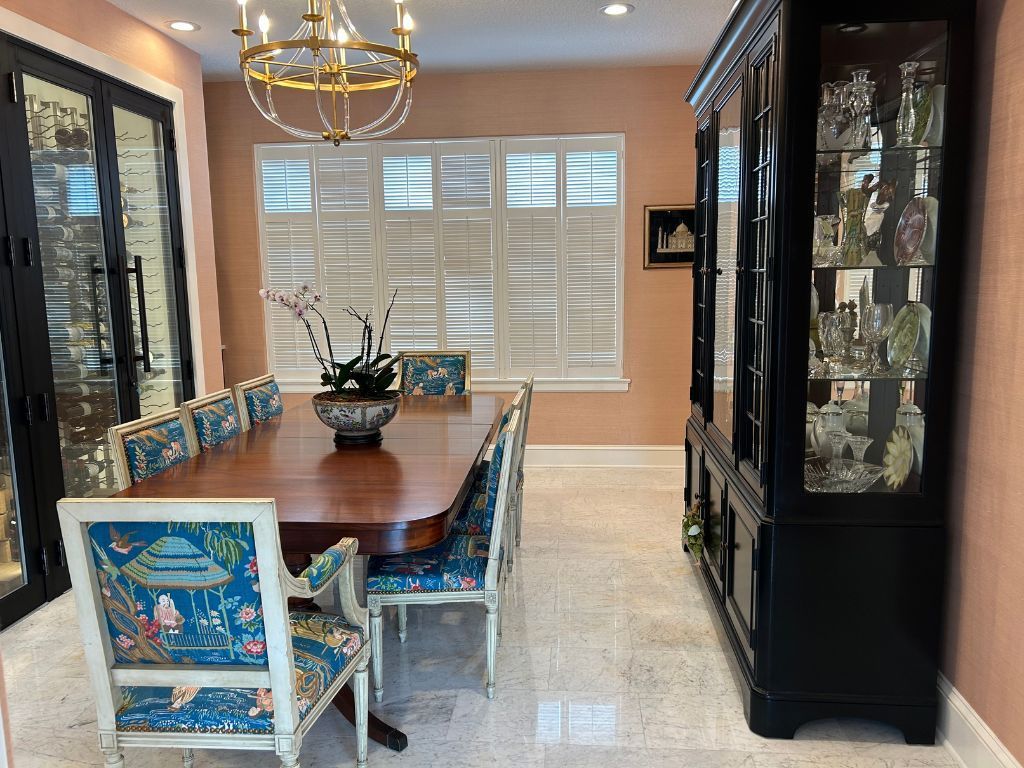 A dining room with a table and chairs and a hutch.