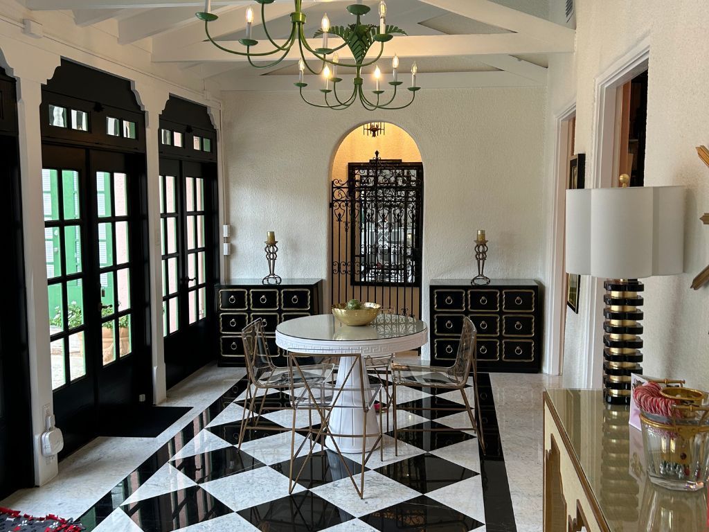 A large room with a checkered floor and a table and chairs.