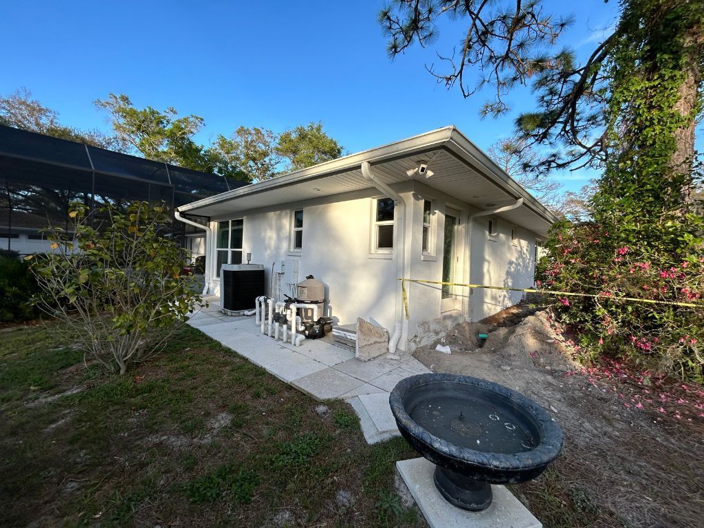 A small white house with a bird bath in front of it