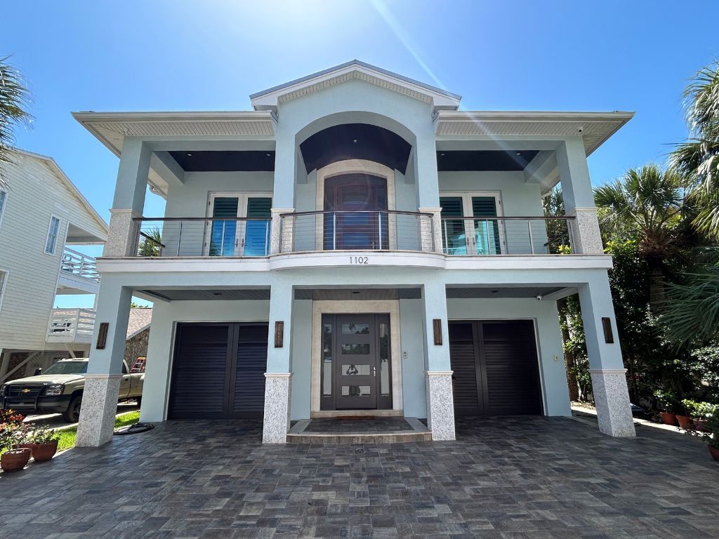 A large house with a brick driveway in front of it