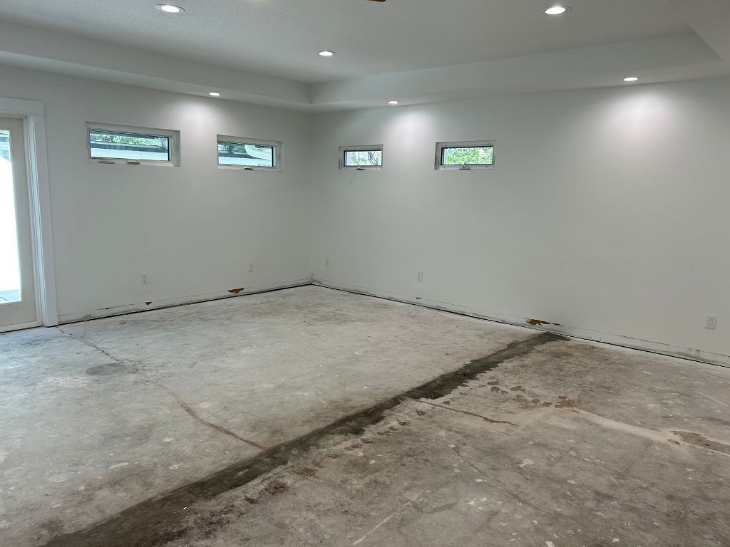 An empty room with a concrete floor and white walls.