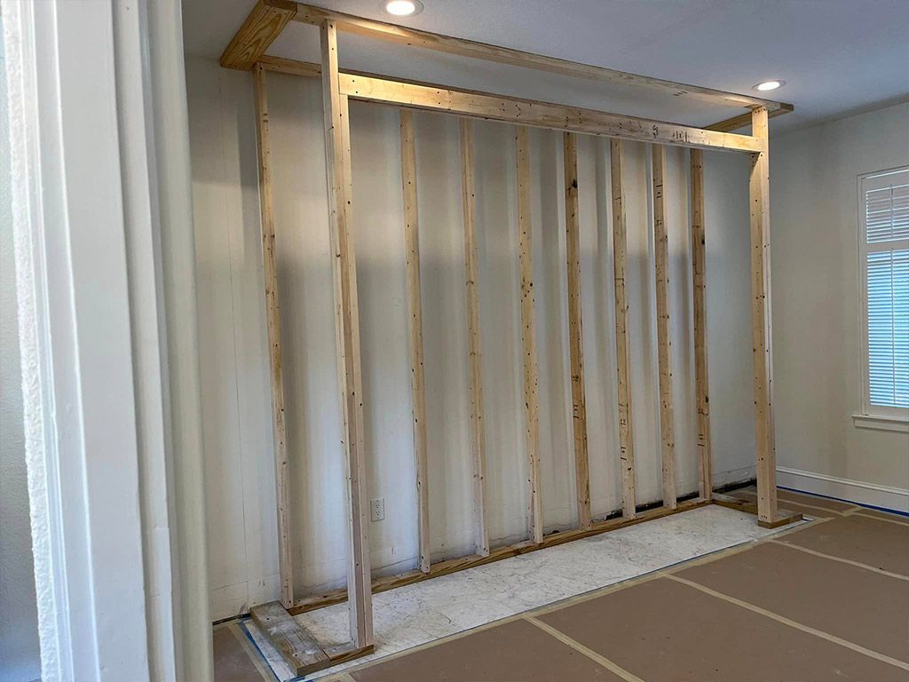 A room with a wooden wall being built in it.
