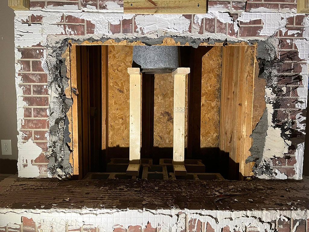 A brick fireplace is being remodeled in a living room.