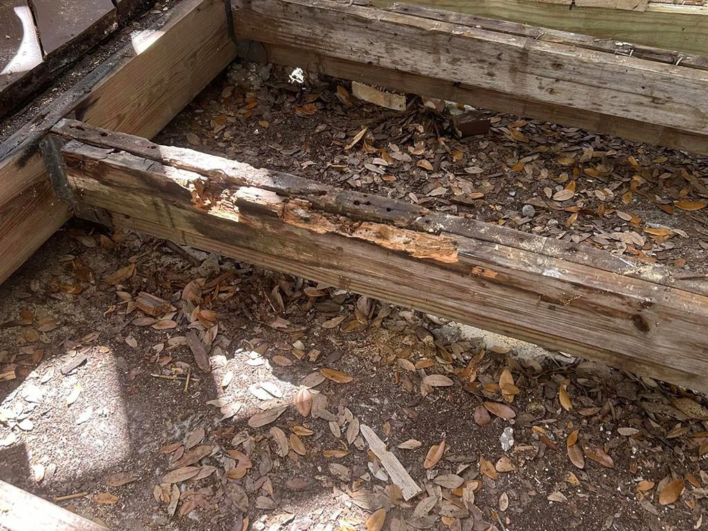 A piece of wood is laying on the ground next to a pile of leaves.
