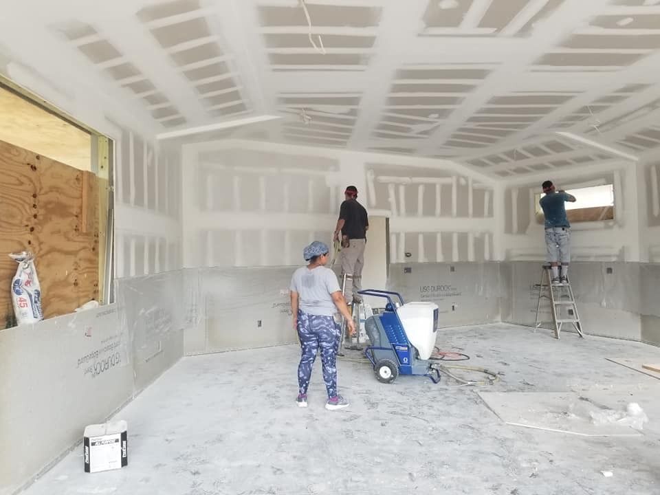 A group of people are painting a room in a house.