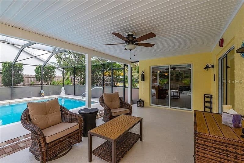 A house with a large lawn in front of it and trees in the background.