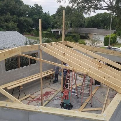 A wooden structure is being built on top of a brick building.