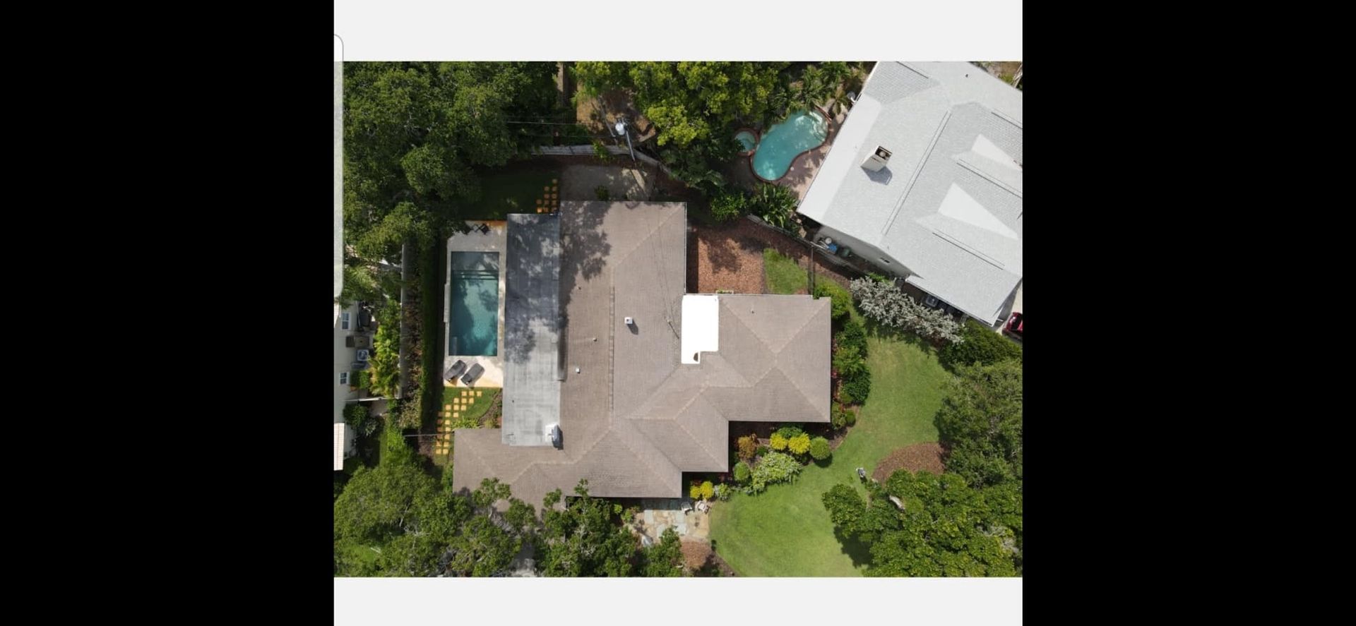 An aerial view of a house with a pool in the backyard.