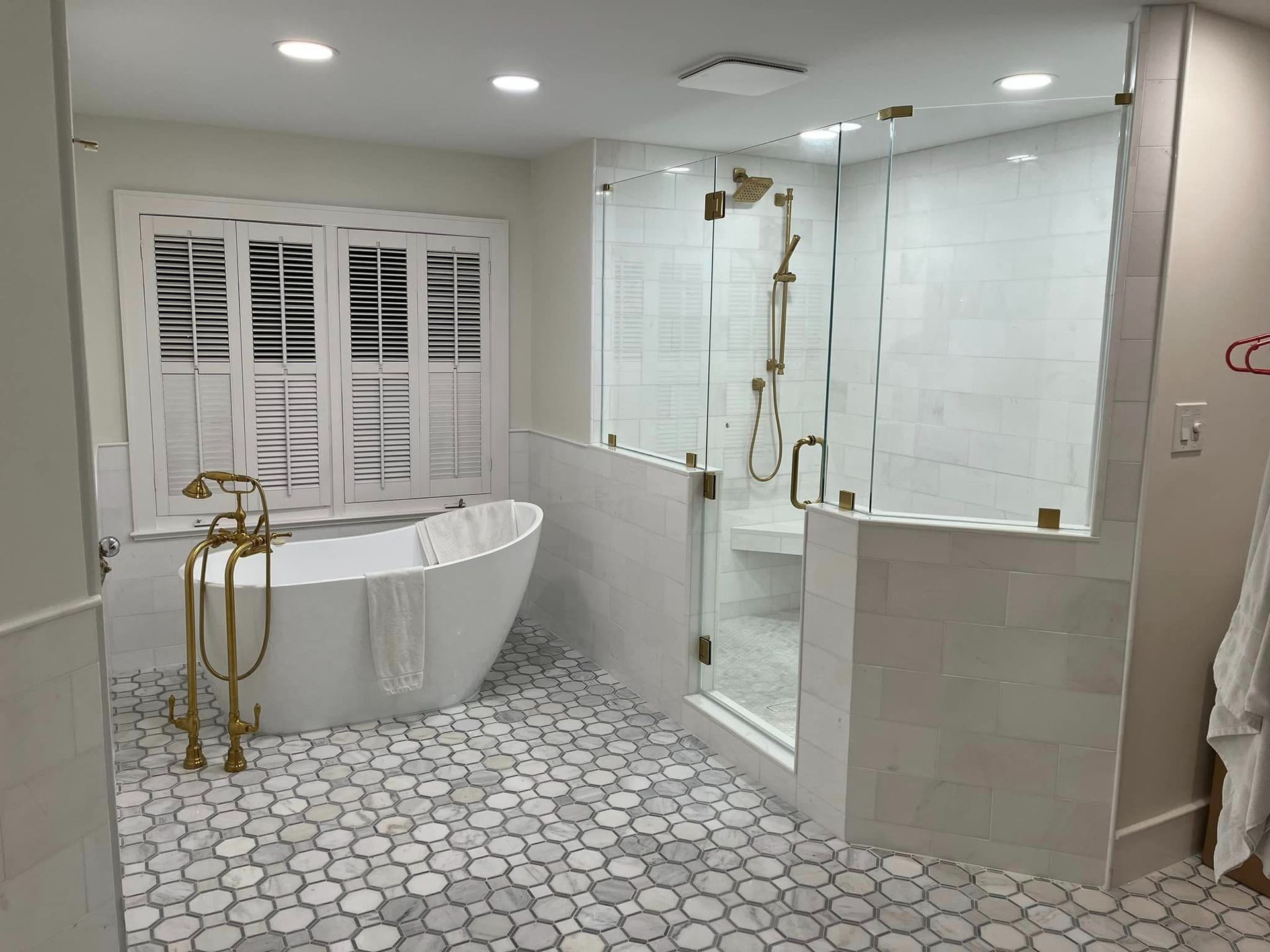 A bathroom with a tub , shower , and window.