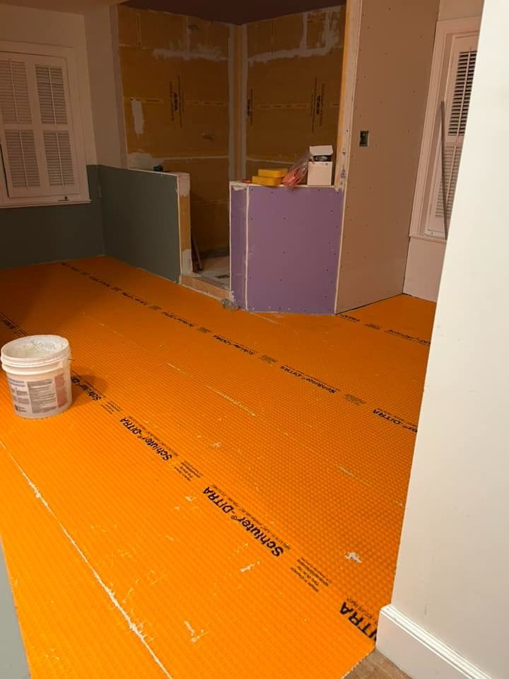 A room with a bucket of paint on the floor.