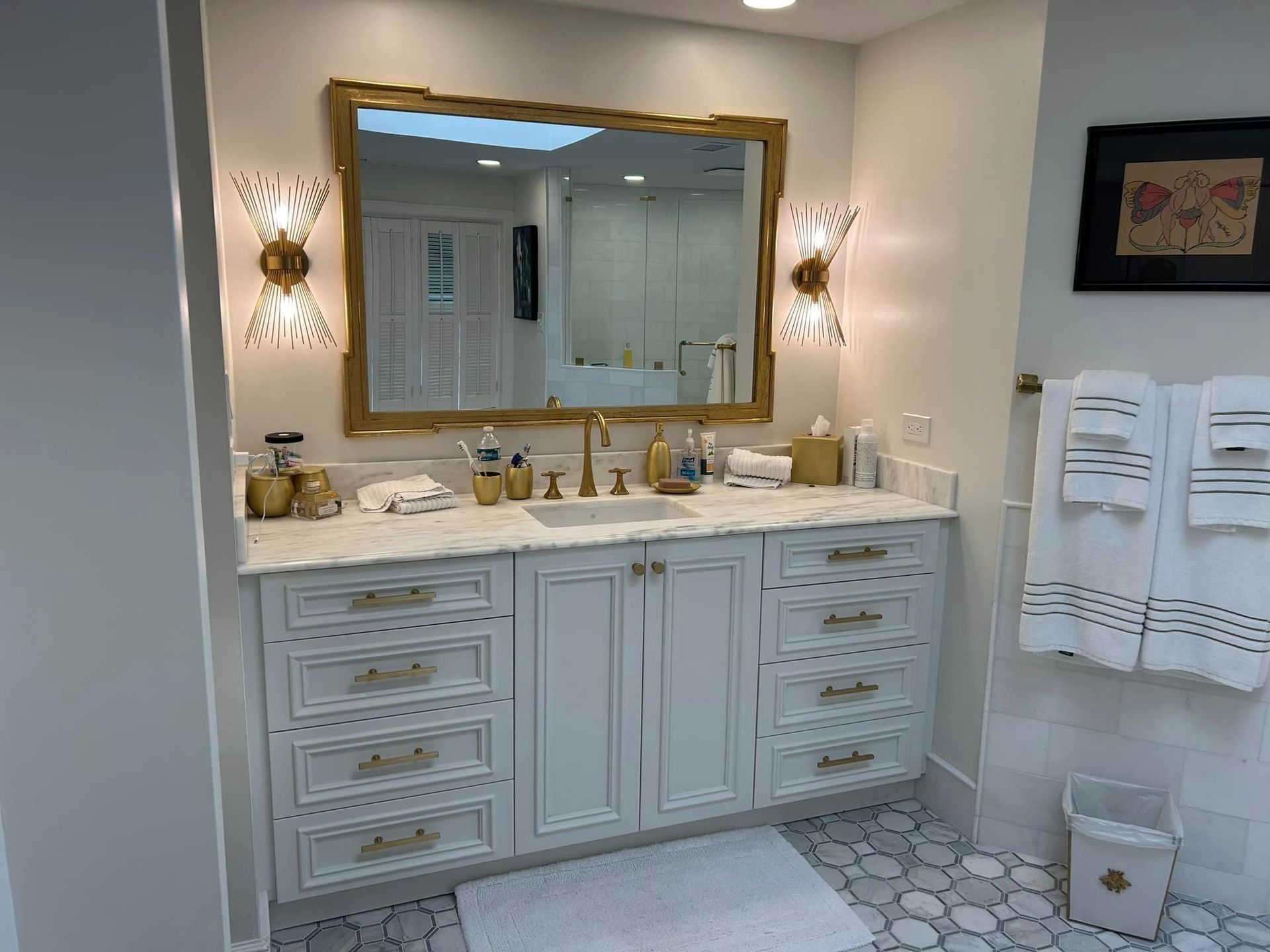 A bathroom with a sink , mirror and towels