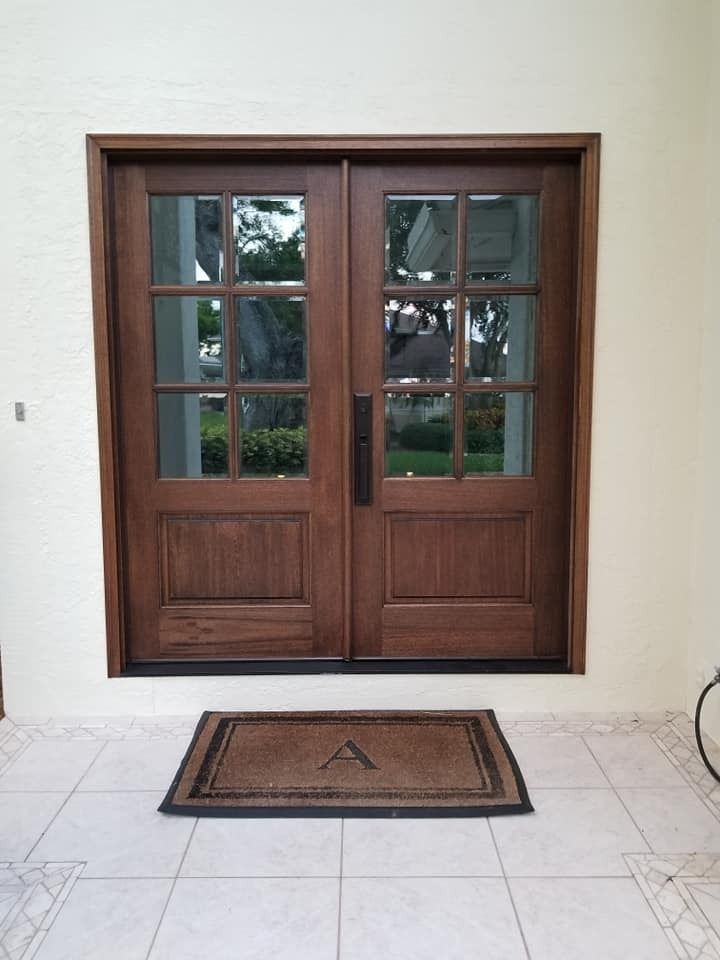 A wooden door with a welcome mat in front of it