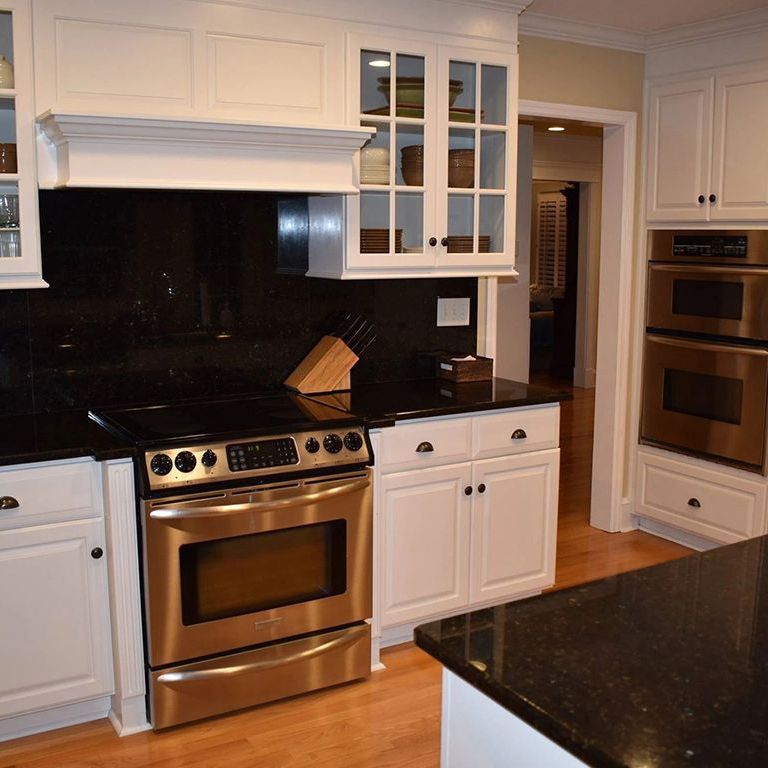 A kitchen with stainless steel appliances and white cabinets