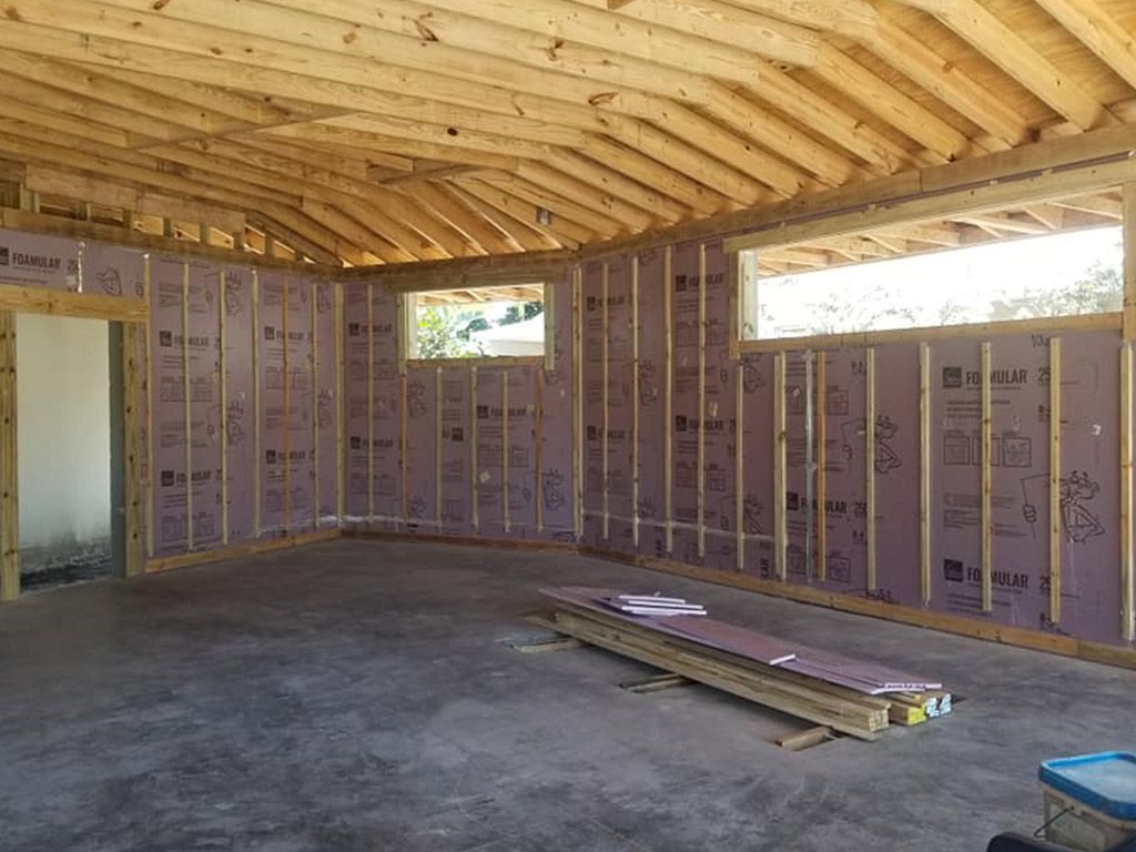 The inside of a building under construction with wooden beams and insulation on the walls.