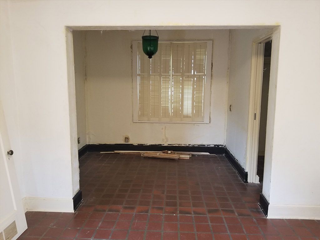 An empty room with a tiled floor and a window