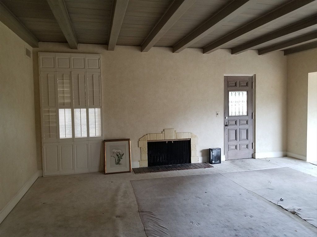 An empty room with a fireplace and a door