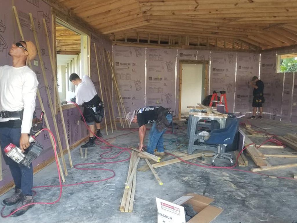 A group of men are working on a house under construction.