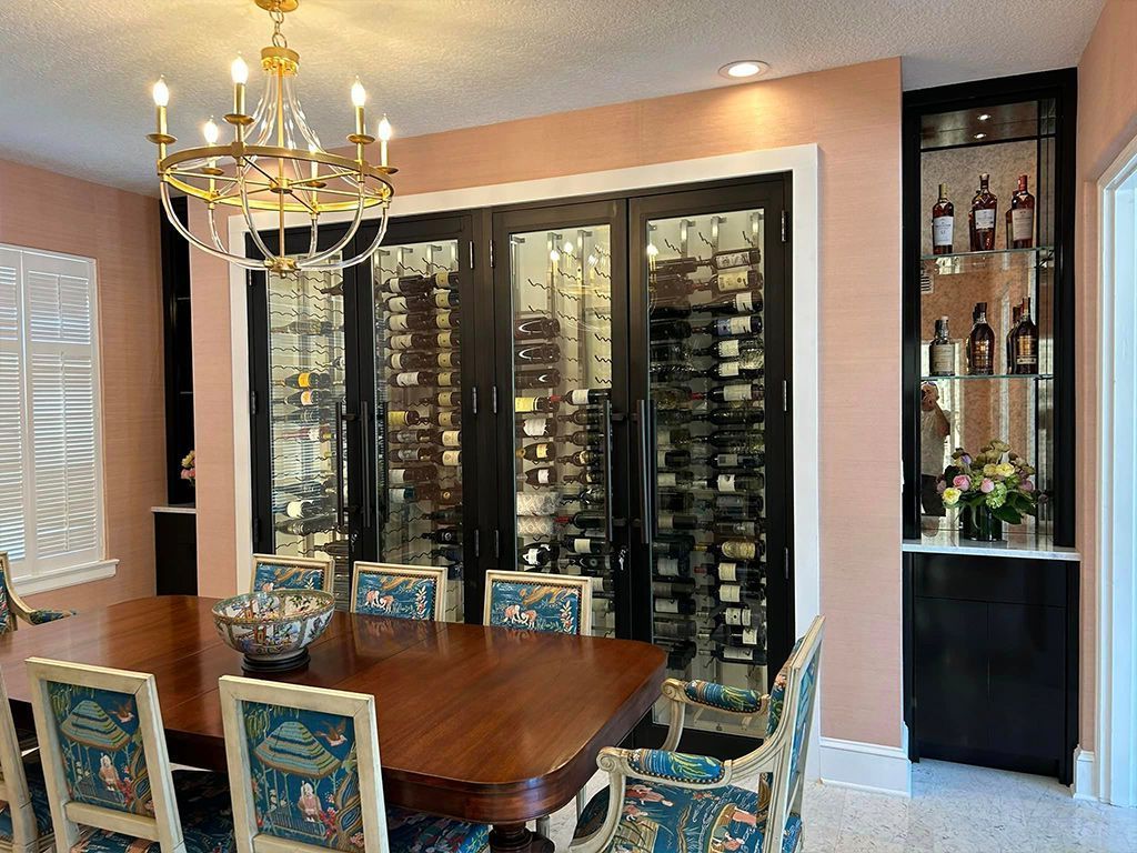 A dining room with a table and chairs and a wine cellar.