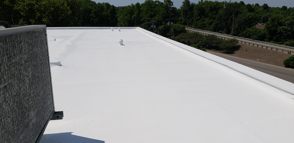 a white roof with trees in the background and a highway in the background .