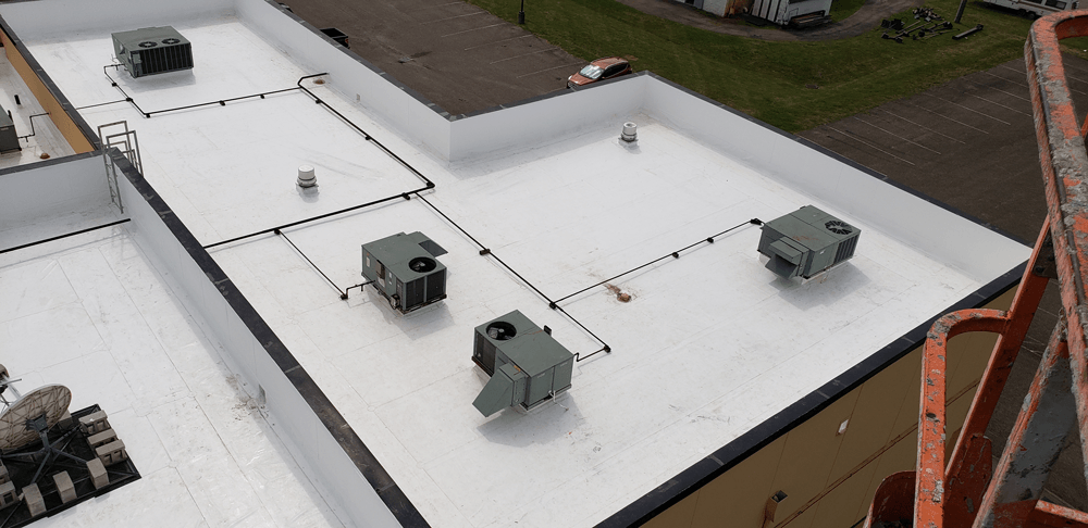 an aerial view of a white roof with a lot of air conditioners on it .